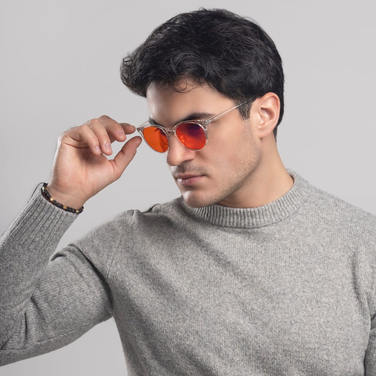 IMG_8955-Miniatura-FHD.jpg Mężczyzna poprawiający okulary z pomarańczowymi szkłami, przezroczysta oprawa, ujęcie z bliska