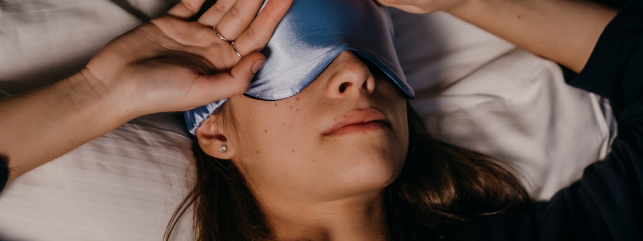 dziewczyna w wieku nastolatki leżąca na poduszce z opaską na oczy Biohac